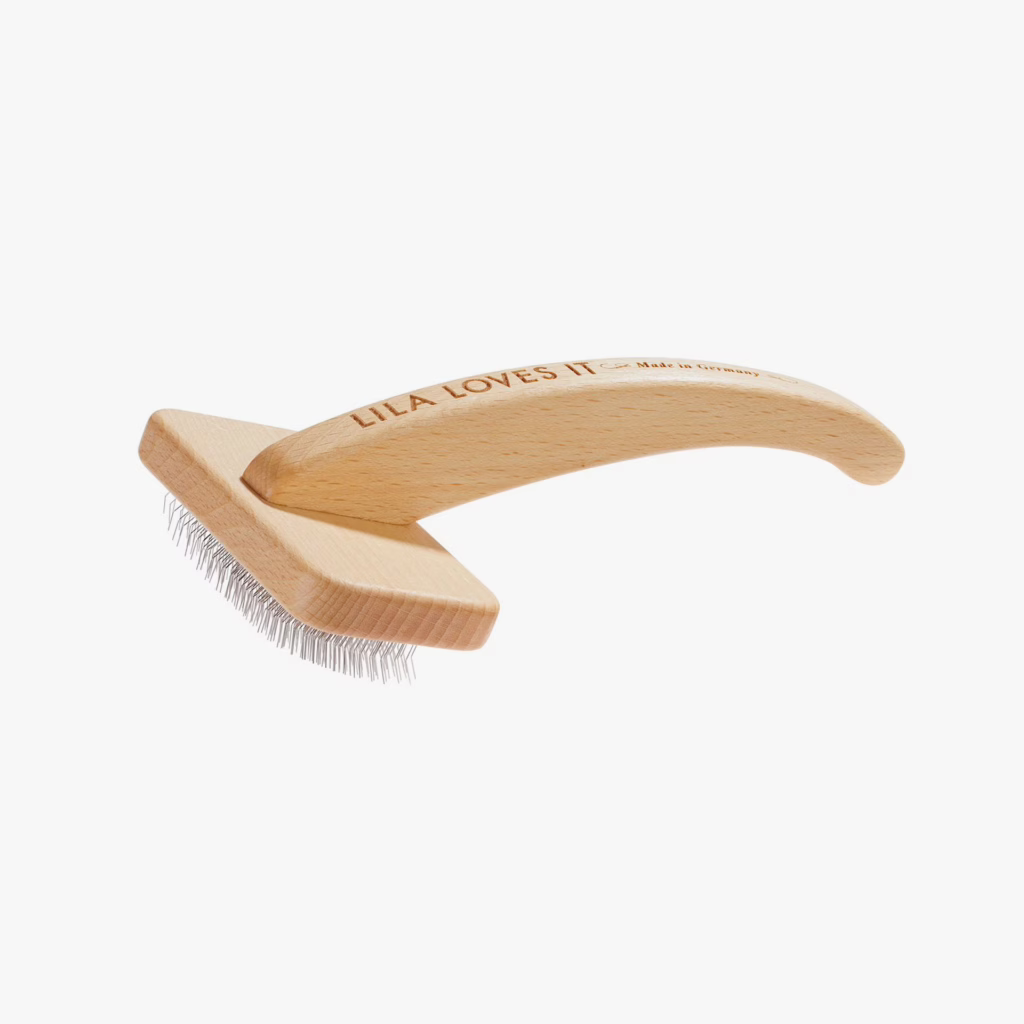 Cepillo para perros de pelo largo de Lila Loves It: elimina nudos y subpelo con suavidad. Mango de madera sostenible y fabricación artesanal alemana.